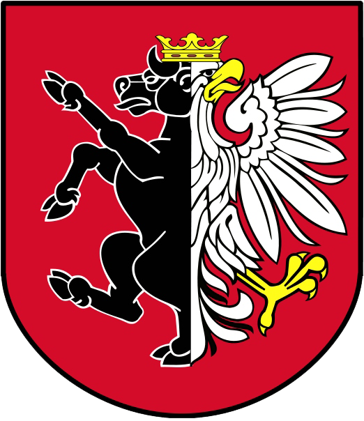 Herb Powiatu Nakielskiego: przedstawia w tarczy dwudzielnej w słup; w polu prawym czarny połubyk, w polu lewym biały połuorzeł, razem tworzące zoomorficzną hybrydę, zwieńczoną koroną. Pole tarczy herbowej koloru czerwonego.