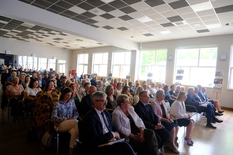 Blisko 80 osób siedzi na krzesłach i patrzy w jednym kierunku. Pilnie słuchają.